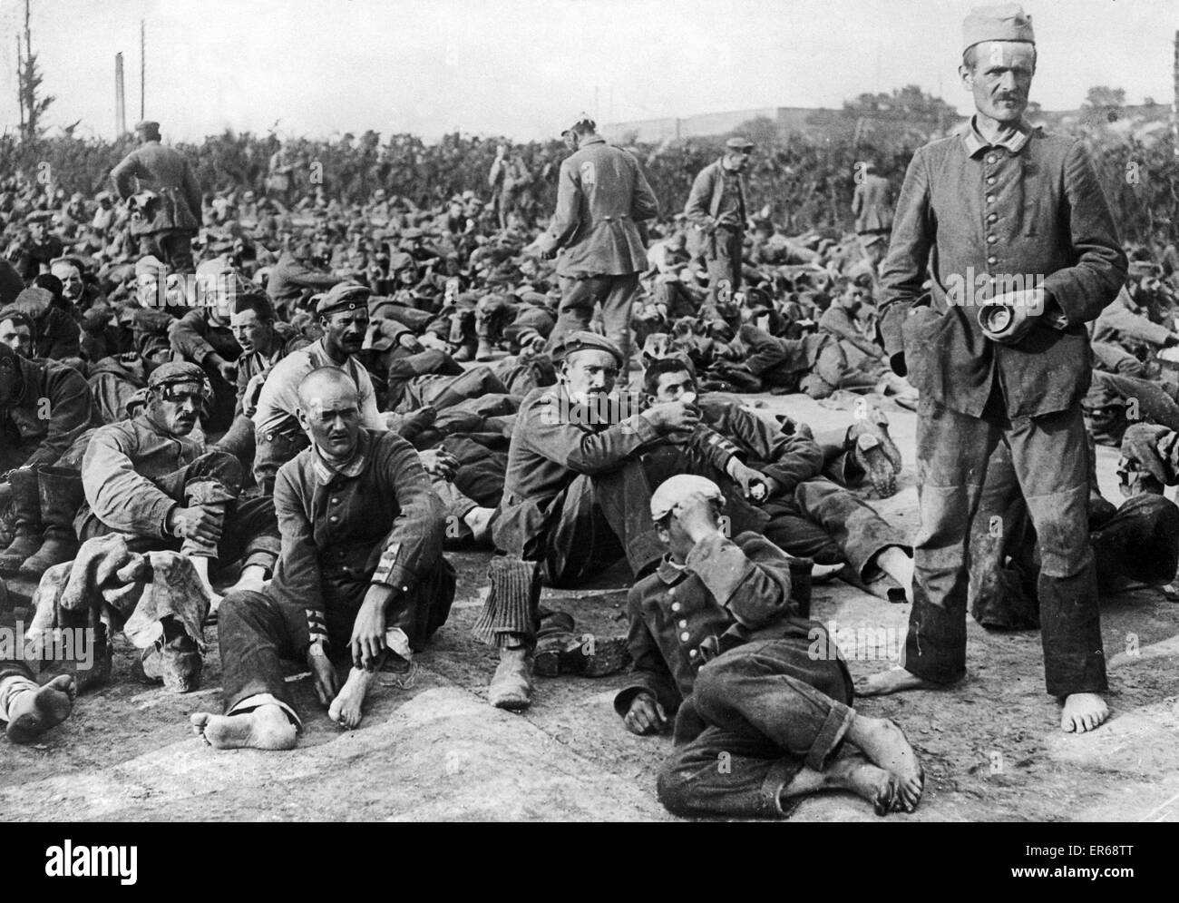 German prisoners of war from the Somme offensive tired and footsore, they have just arrived at their camp. The first thing they do is to ease their feet by removing their heavy boots. Stock Photo