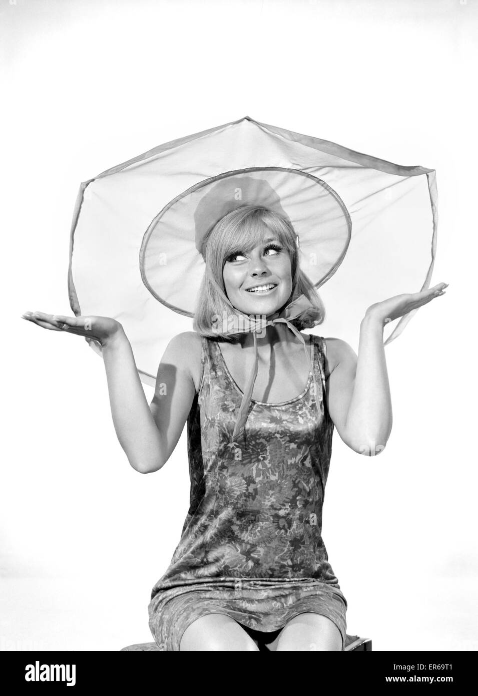 Clothing: Fashion: Hats: Woman wearing umbrella hat. Model: Marilyn Rickard. 1966 B2021-004 Stock Photo