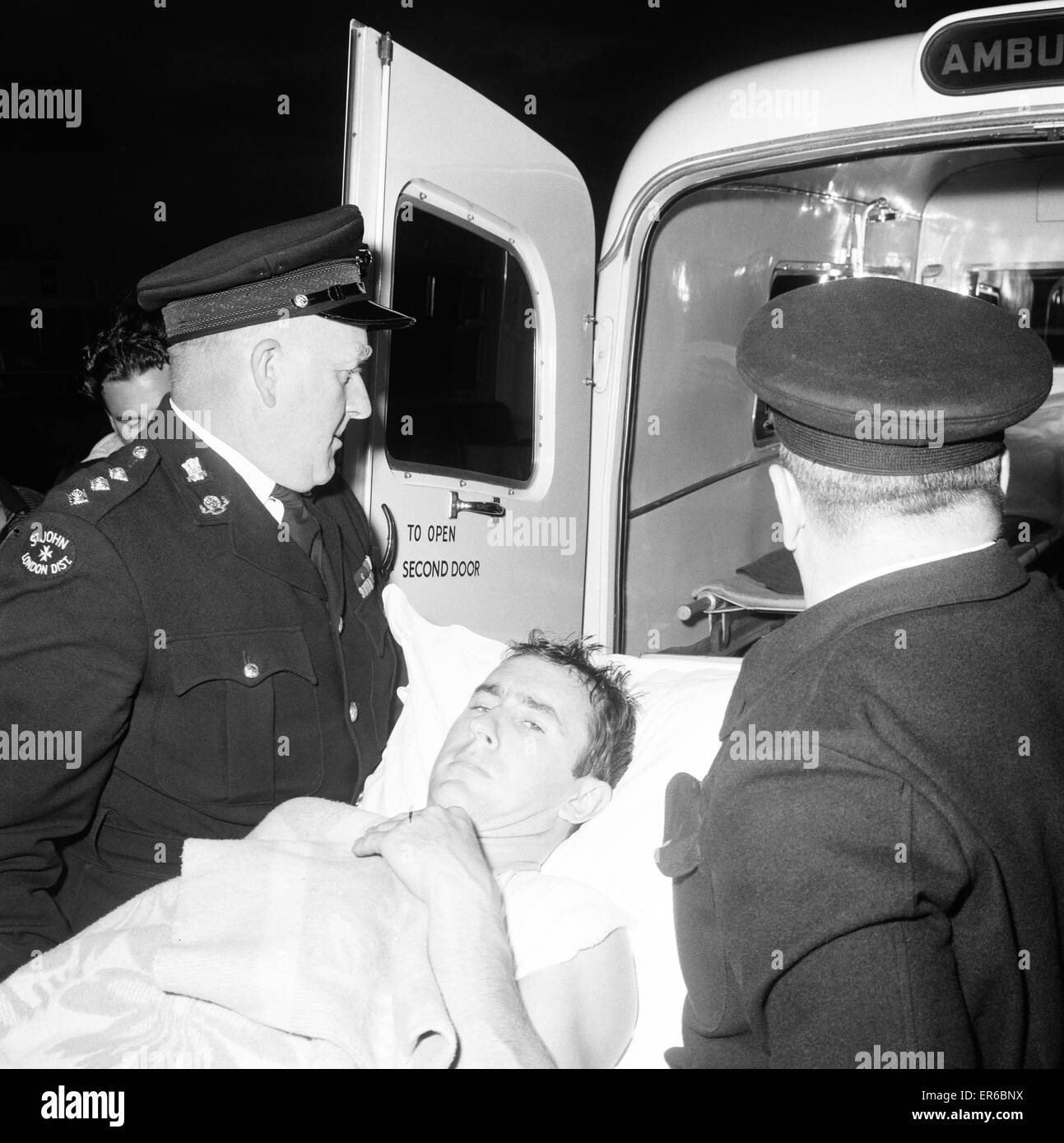 Jackie Stewart, Formula One Motor Racing Driver pictured being transferred from ambulance after arrival at St Thomas's Hospital, Westminster, London, Sunday 12th June 1966. Jackie Stewart was the only driver injured during an incredible first lap at the B Stock Photo