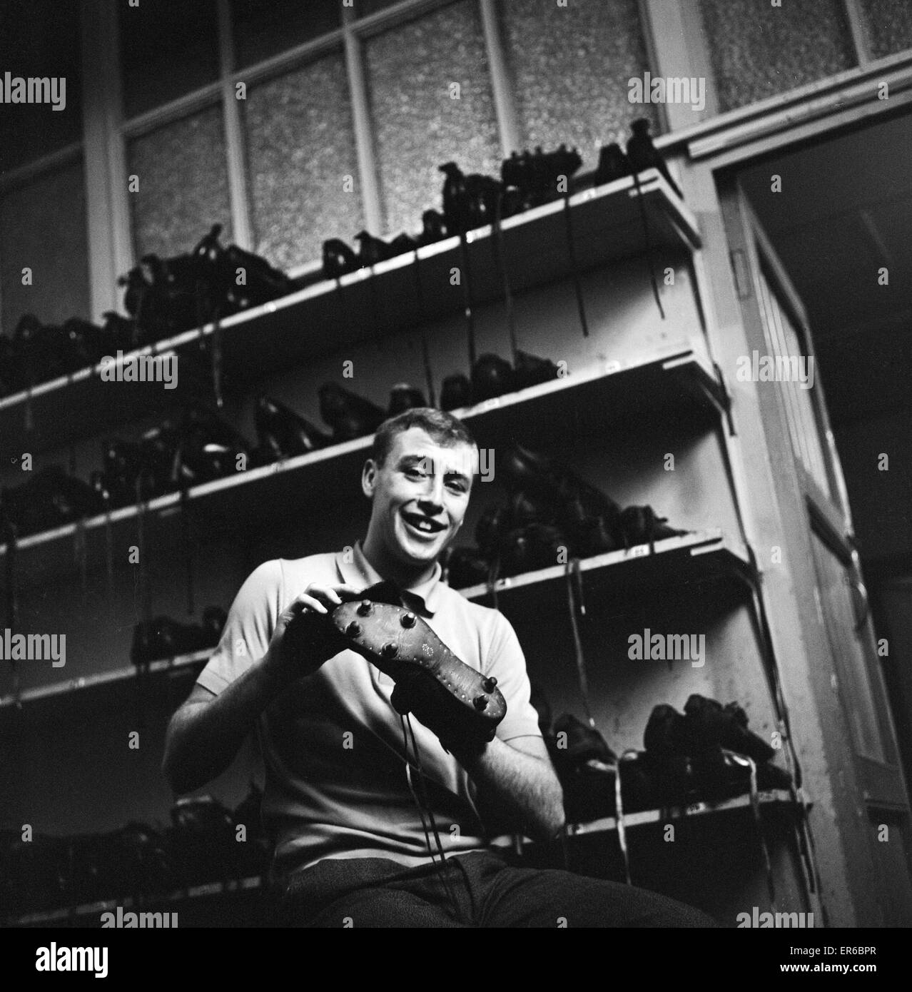 Blackburn Rovers forward John Byrom cleaning his football boots. December 1964. Stock Photo