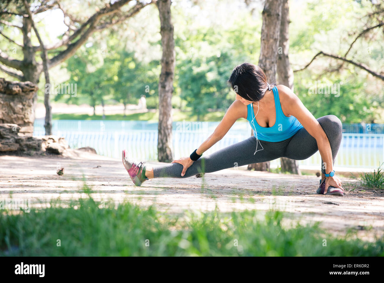 Sporty woman doing stretching exercise outdoors in park Stock Photo - Alamy