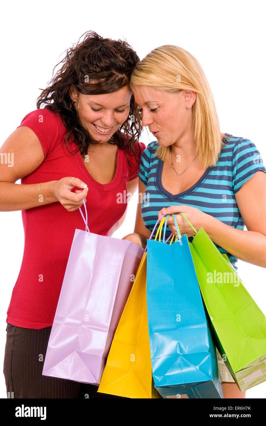 Look what I bought. Two girls looking in each other's shopping bags on white background Stock Photo