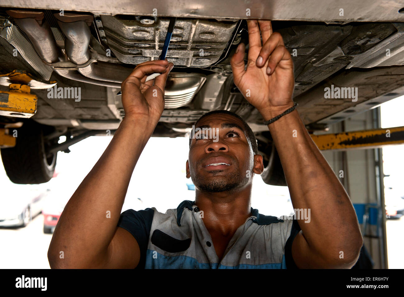 Good Looking African American Mechanic Checking Out Under Carriage of