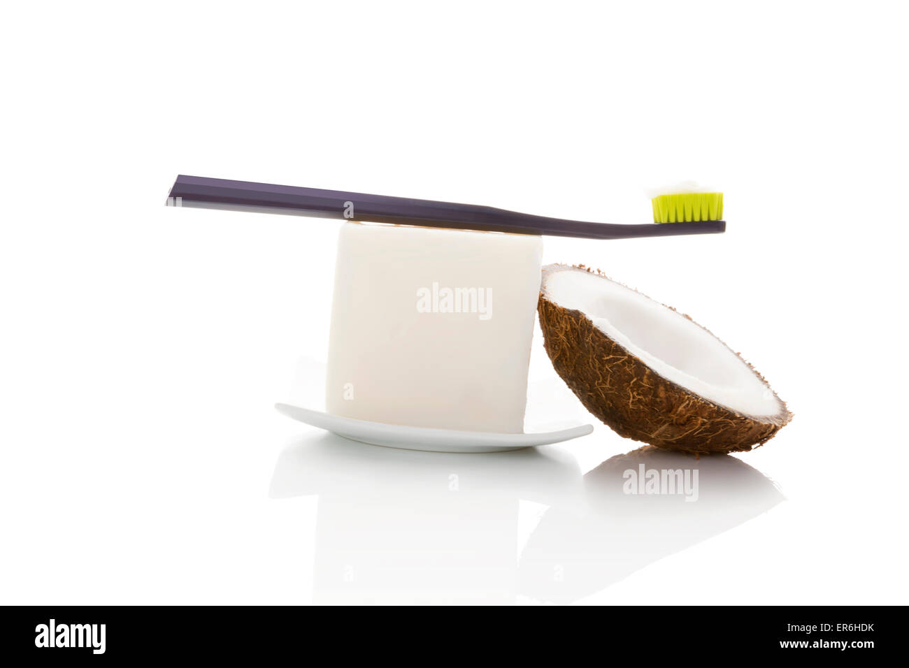 Hard organic coconut oil with toothbrush and coconut isolated on white