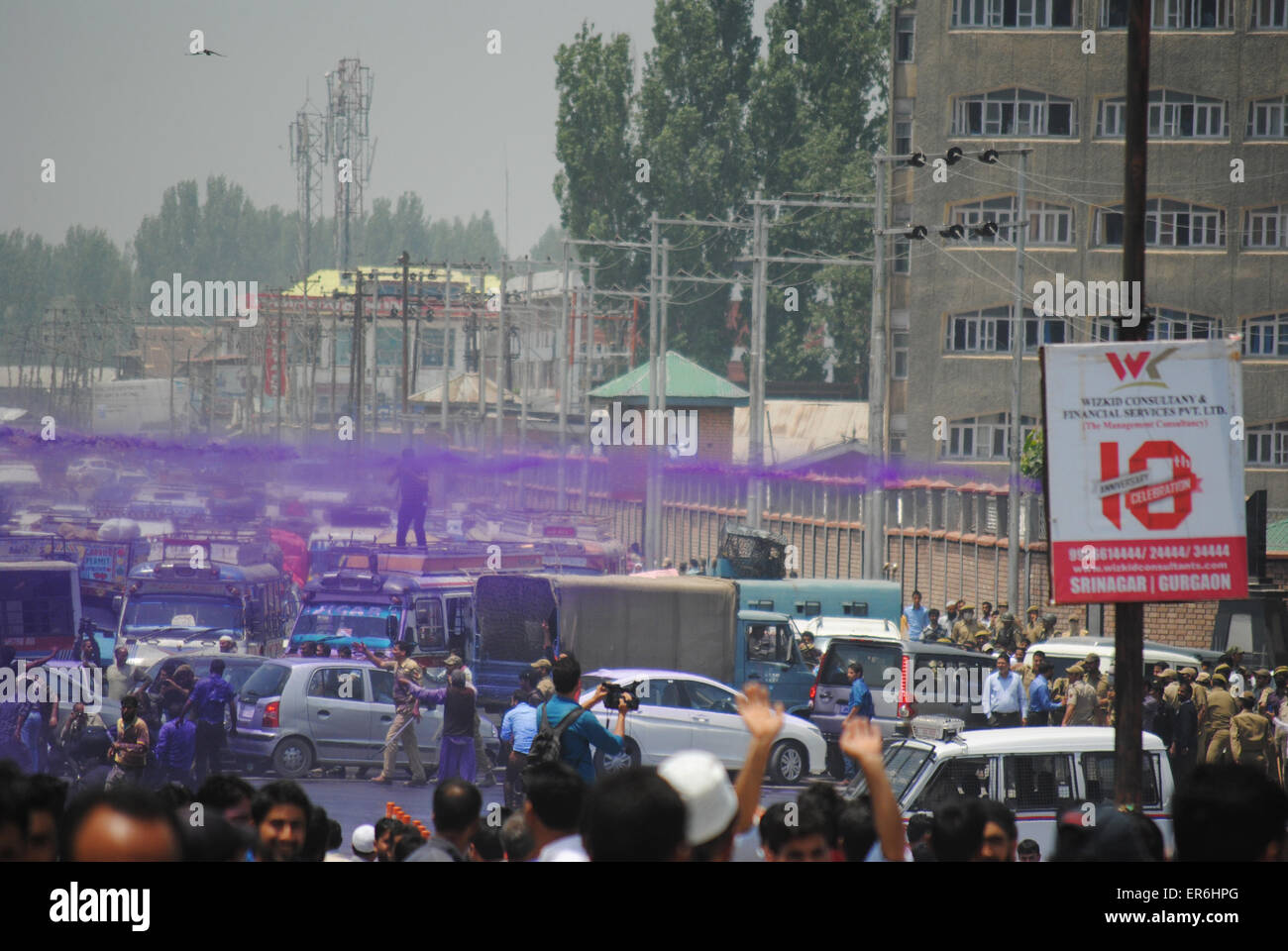 Srinagar, Kashmir. 28th May, 2015. Jammu and Kashmir government employees shouting anti-government slogans as Police can charge and sprayed purple-colored water from water cannon to disperse them during a protest in Srinagar, on Thursday. Police detained dozens of employees during the protesters. The employees had planned to picket the Civil Secretariat, which houses offices of the Chief Minister, ministers Mufti Mohd Sayed and top bureaucrats Credit:  NISARGMEDIA/Alamy Live News Stock Photo