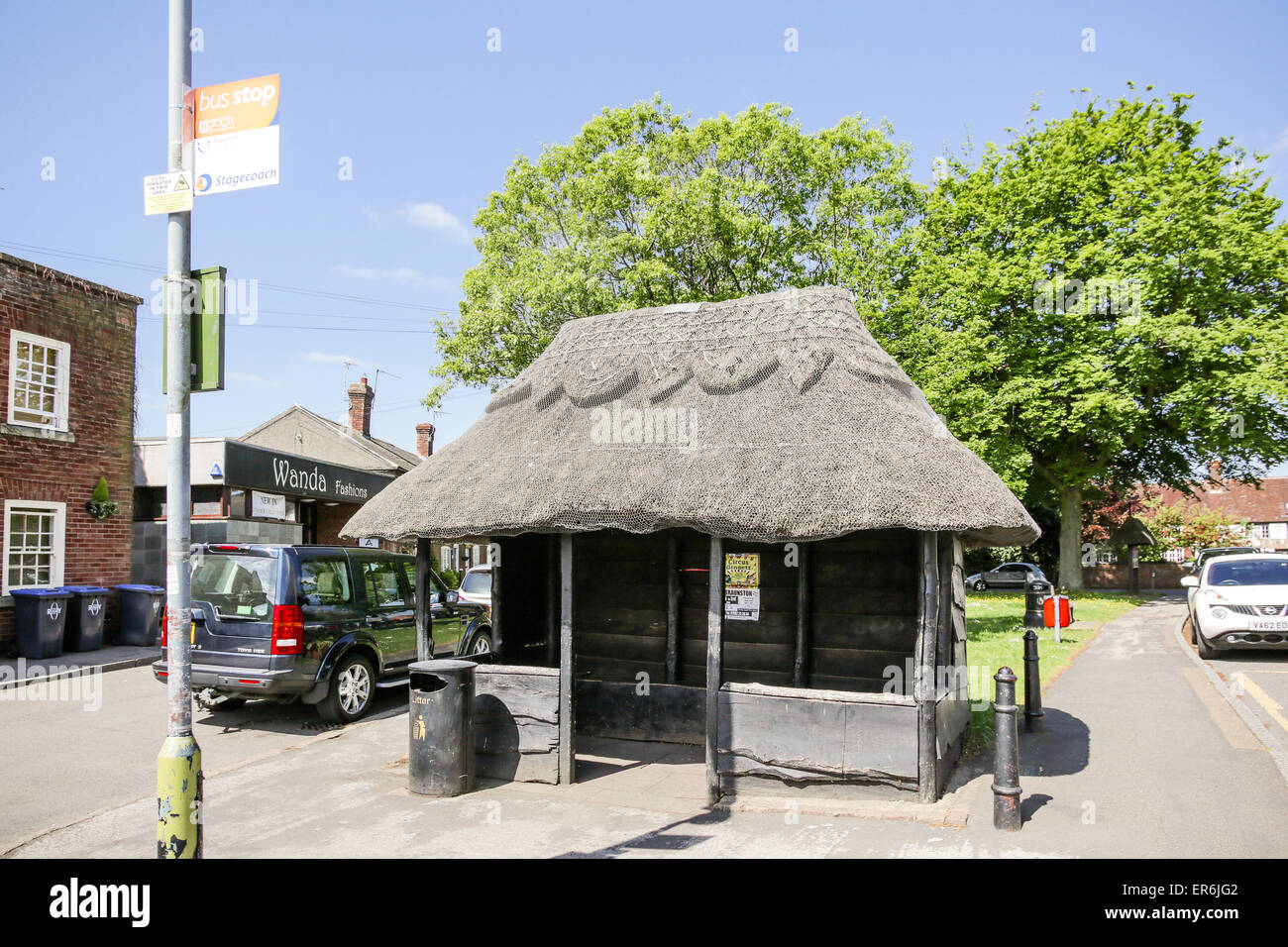 A thatched bus stop in a village location in England Stock Photo
