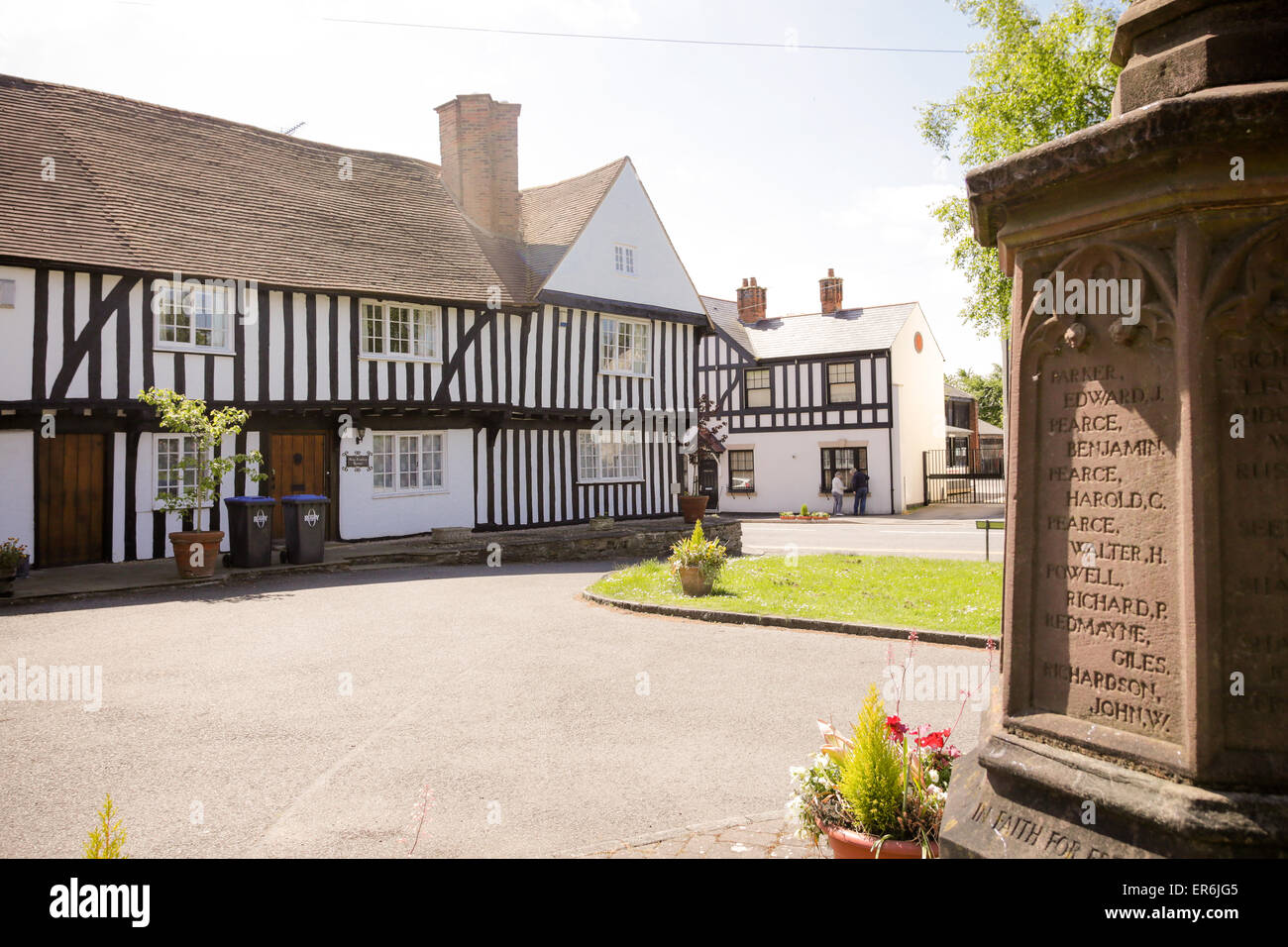 A half timbered old building near to a war memorial in an English village Stock Photo