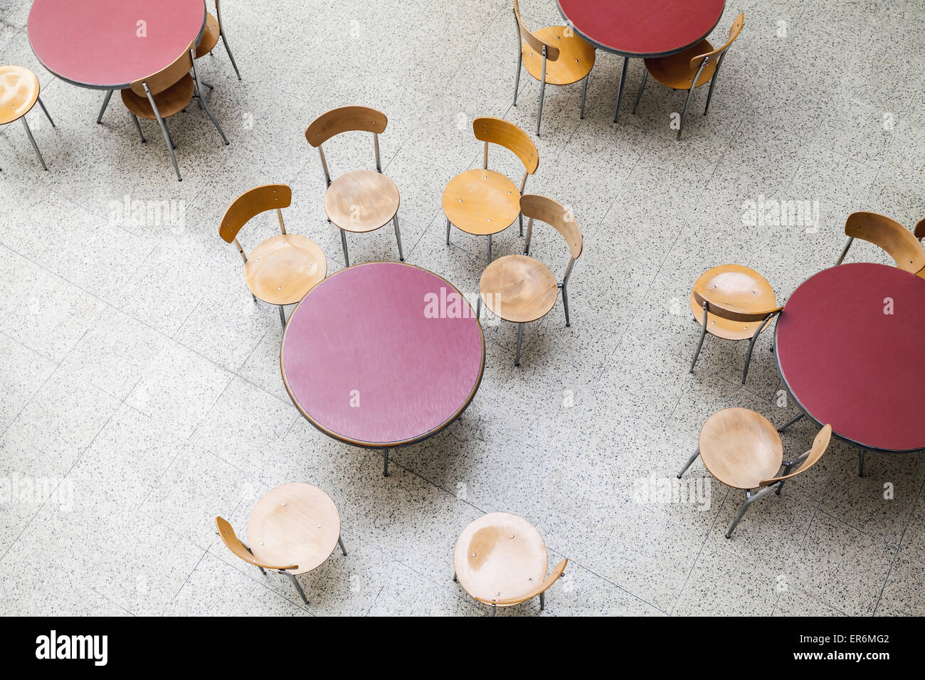 Round tables and chairs around stand in an empty cafe interior, top view Stock Photo