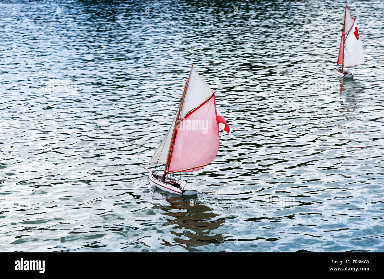 Traditional small wooden sailing toy boats in the pond of park Jardin du Luxembourg, Paris, France Stock Photo