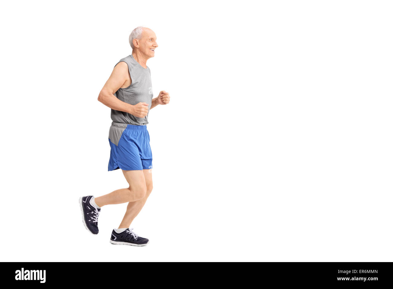 Profile studio shot of a cheerful senior jogging in sportswear isolated on white background Stock Photo