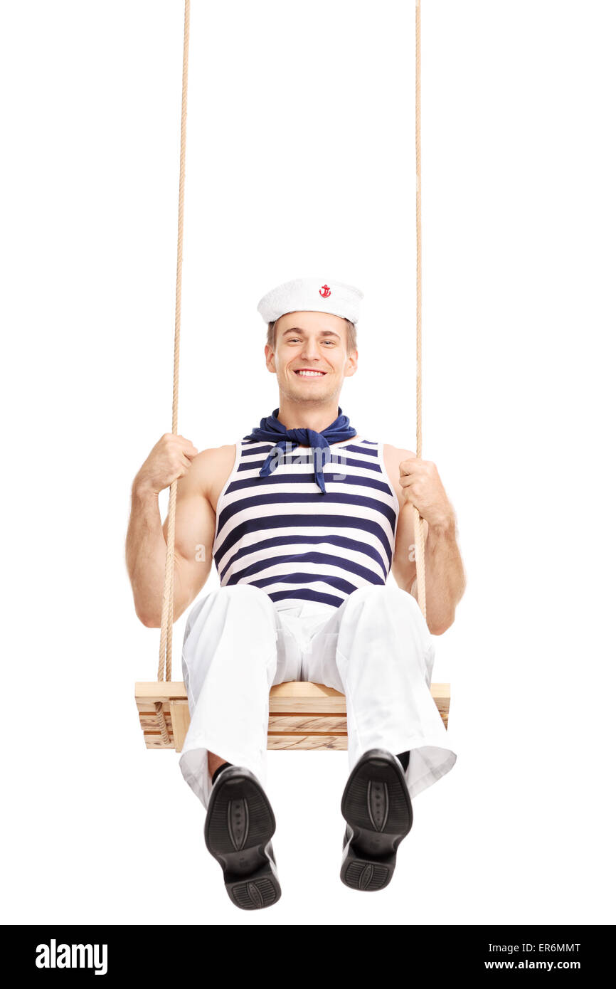 Vertical shot of a cheerful young sailor swinging on a swing and looking at the camera isolated on white background Stock Photo
