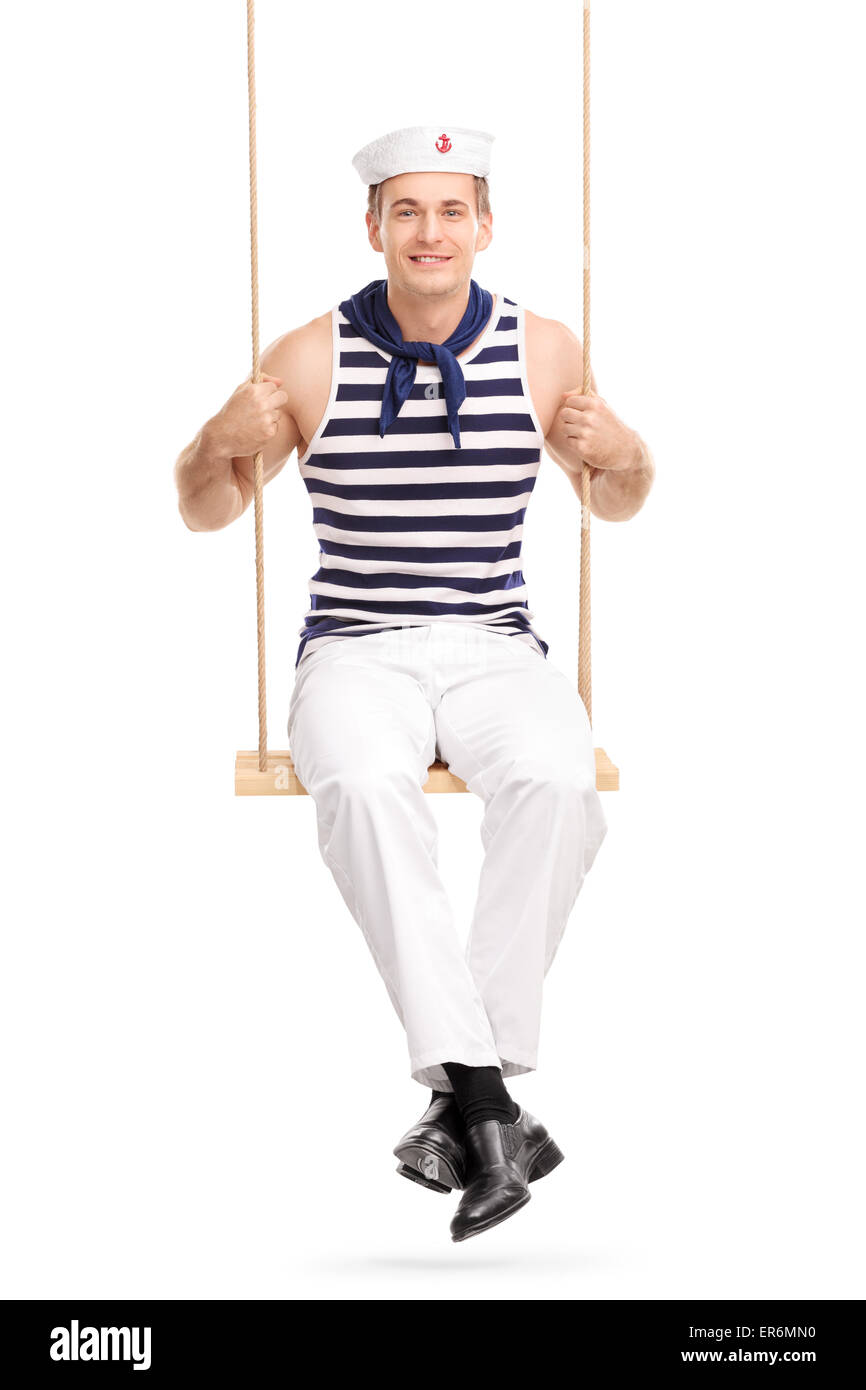 Vertical shot of a young male sailor sitting a swing and looking at the ...