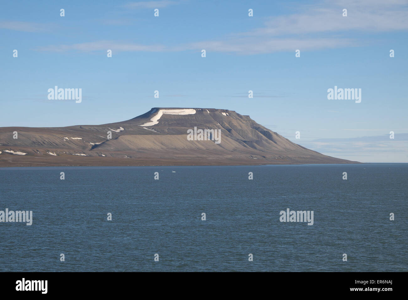 Flat topped mountain near Kapp Waldburg, Freemansundet, south Barentsoya, Svalbard (note huge terminal moraine deposit directly below snow). Stock Photo