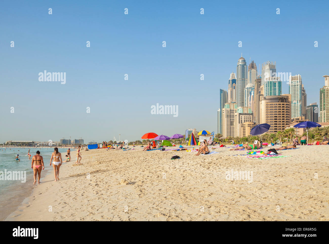 Sunbathers and tourists on the Public Dubai Beach at JBR (Jumeirah Beach Resort) , Dubai, United Arab Emirates, UAE, Middle east Stock Photo