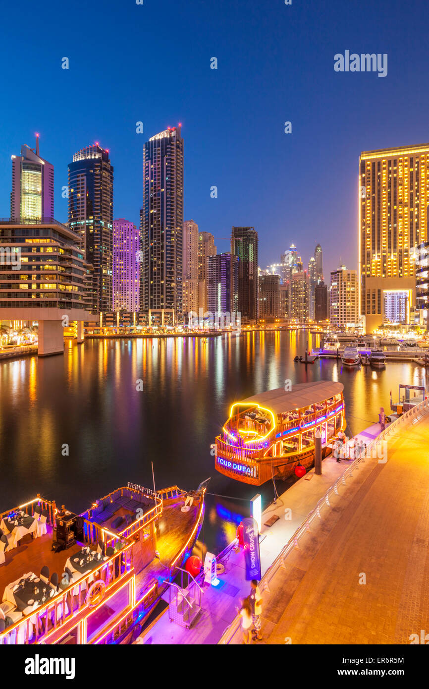 Dubai Marina Skyline and tourist boats at night Dubai City United Arab Emirates UAE Middle east Stock Photo