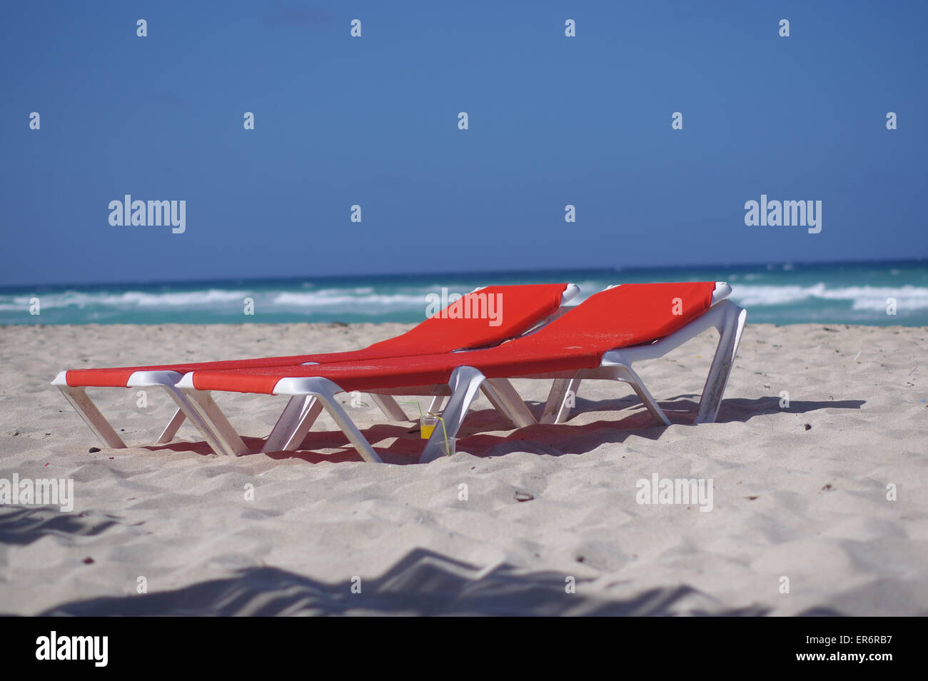 Red lounge chairs on the spectacular white beach of Cayo Coco Stock Photo