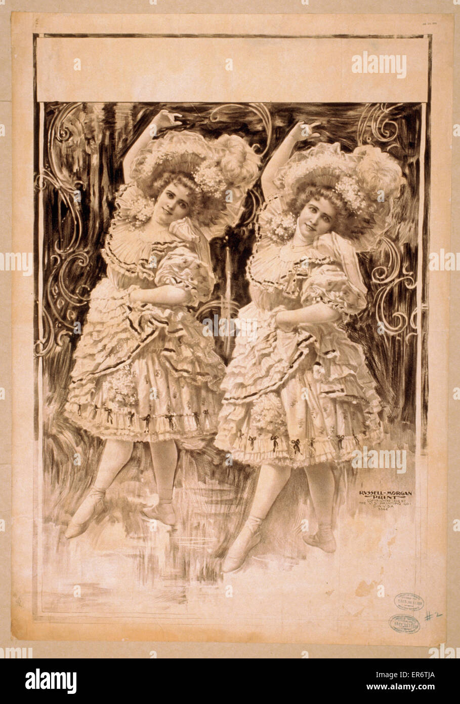 Two women dancing in ruffled costumes and hats Stock Photo