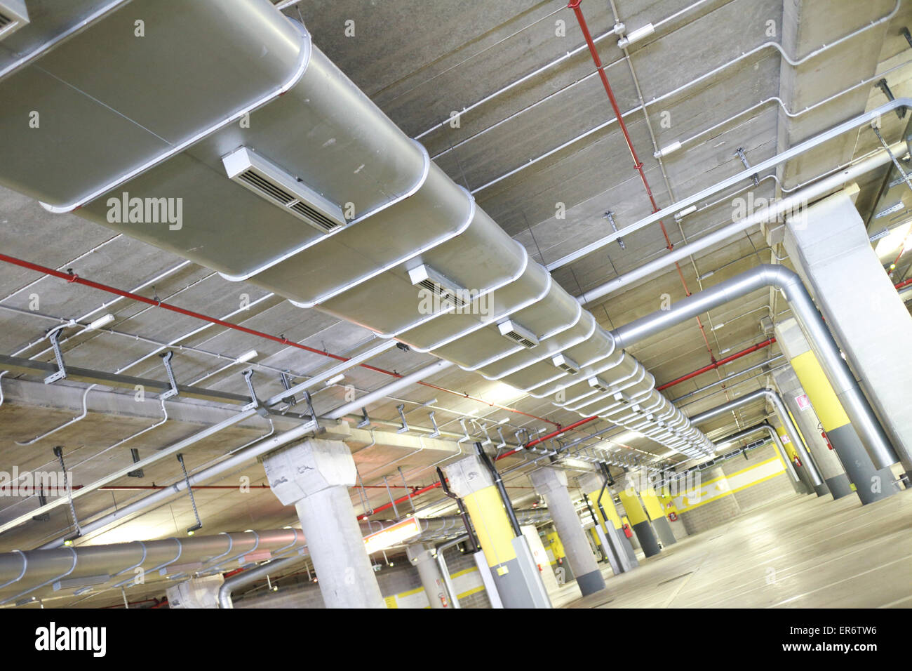 Underground park of a mall with columns and ventilation ducts Stock Photo