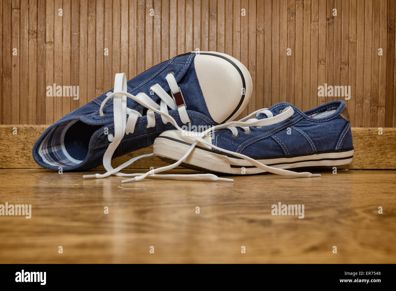 Canvas sneakers blue on the old wooden floor Stock Photo - Alamy