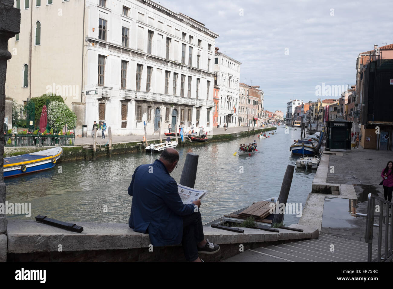 The Volgalonga, annual rowing race in Venice Italy. 41st annual Volgalonga. Man reading newspaper in Venice Italy. Stock Photo