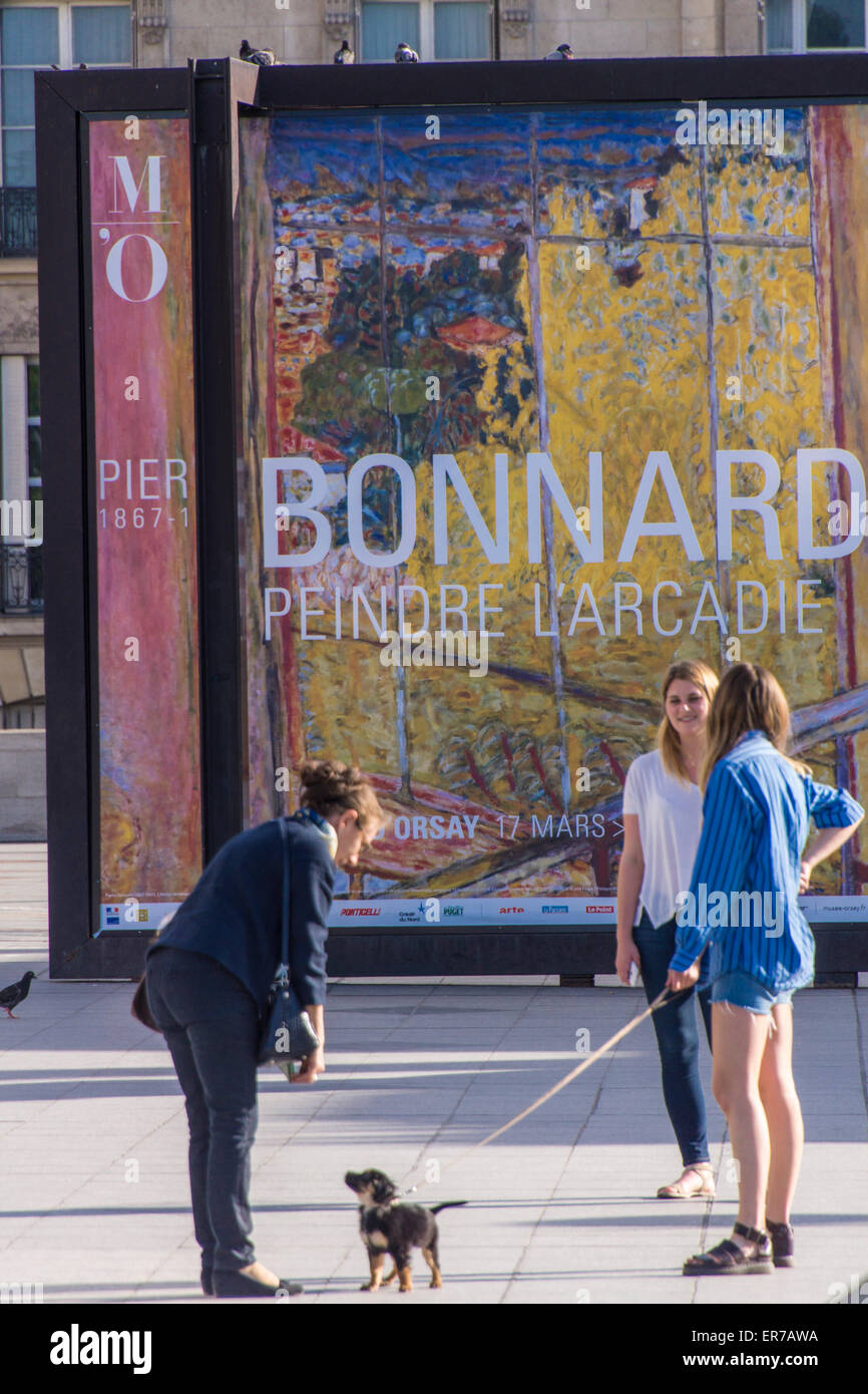 Paris, France. A poster at the Quay D'orsay inviting to a Pierre Bonnard exhibition. Three girls and a dog in the background. Stock Photo