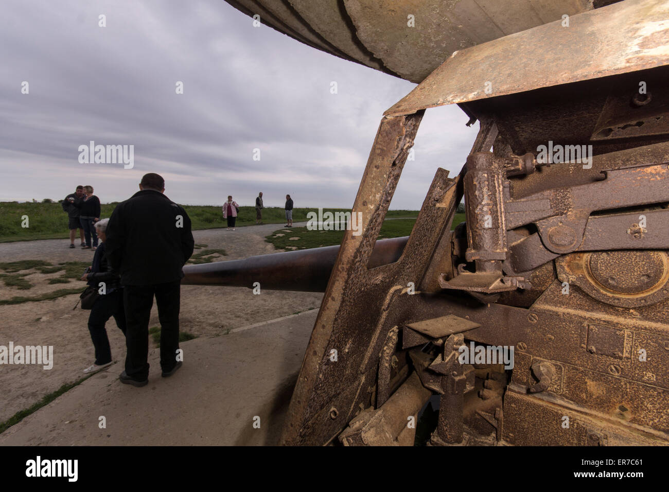 Lounges sur mer, Normandy, France. Tourists near an old, rusting German gun at dusk. Stock Photo