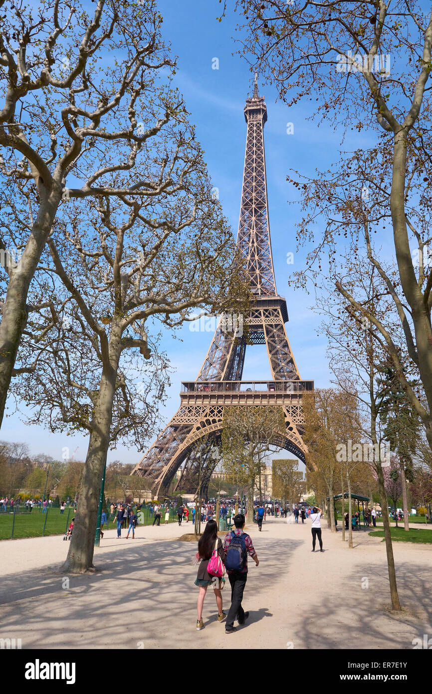 Friends walking though the 'Champ de Mars' towards the 'Eiffel tower' - Paris, France Stock Photo