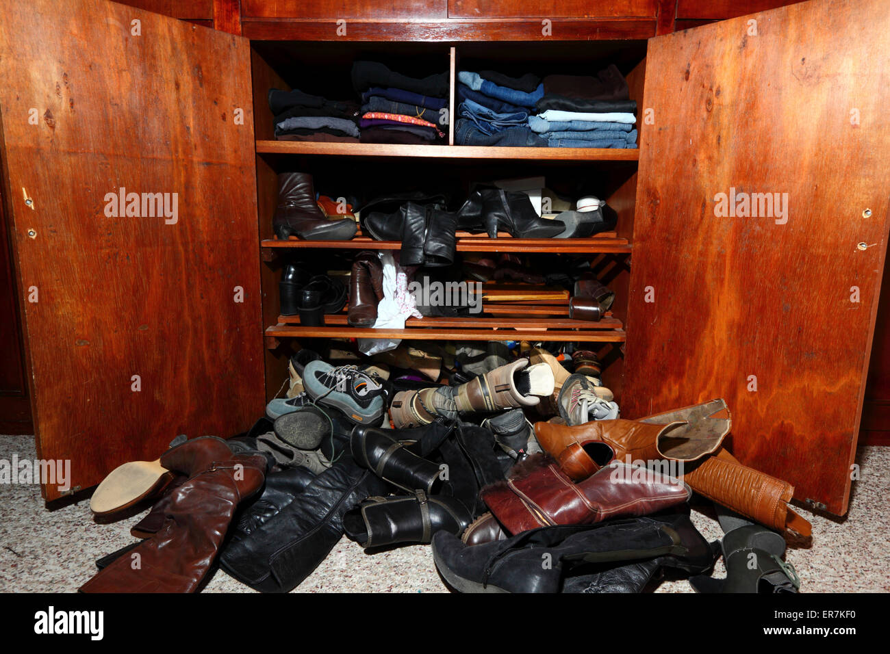 Selection of womens shoes scattered untidily on floor in front of wardrobe in bedroom Stock Photo