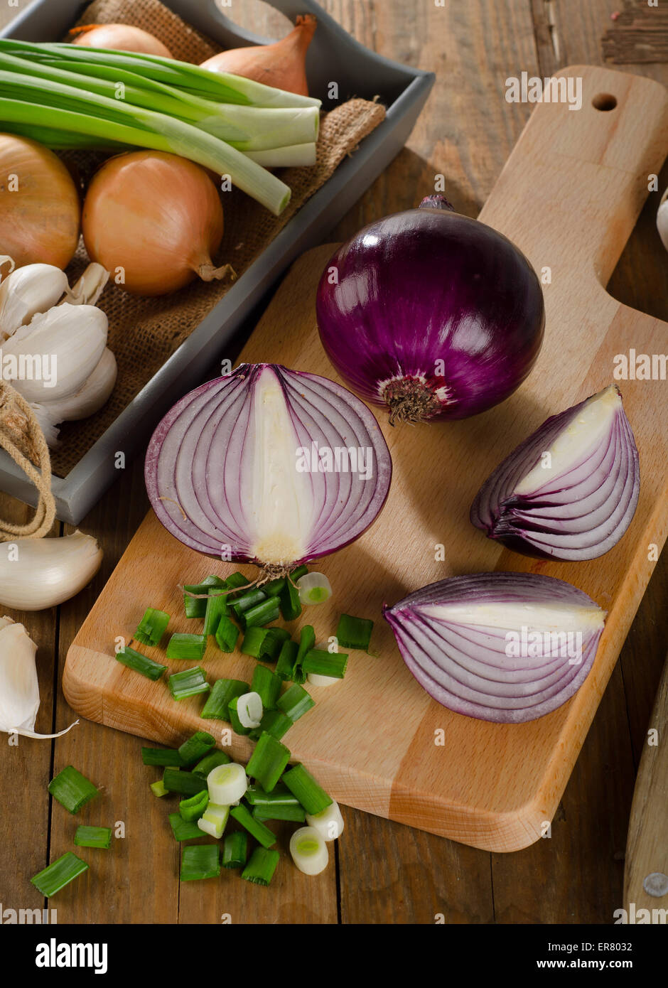 Different fresh onions on a wooden cutting board Stock Photo - Alamy
