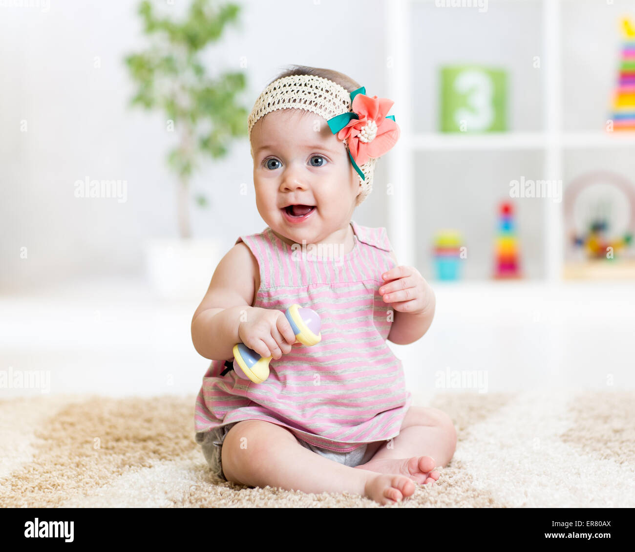 cute baby girl playing with toy indoors Stock Photo