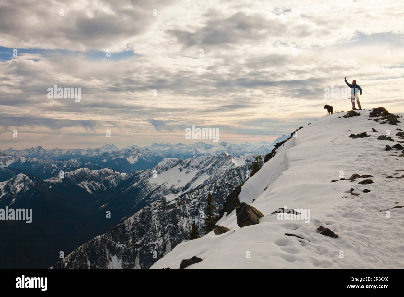 A backpacker poses for a picture with his dog in the Cascade Mountain Range. Stock Photo