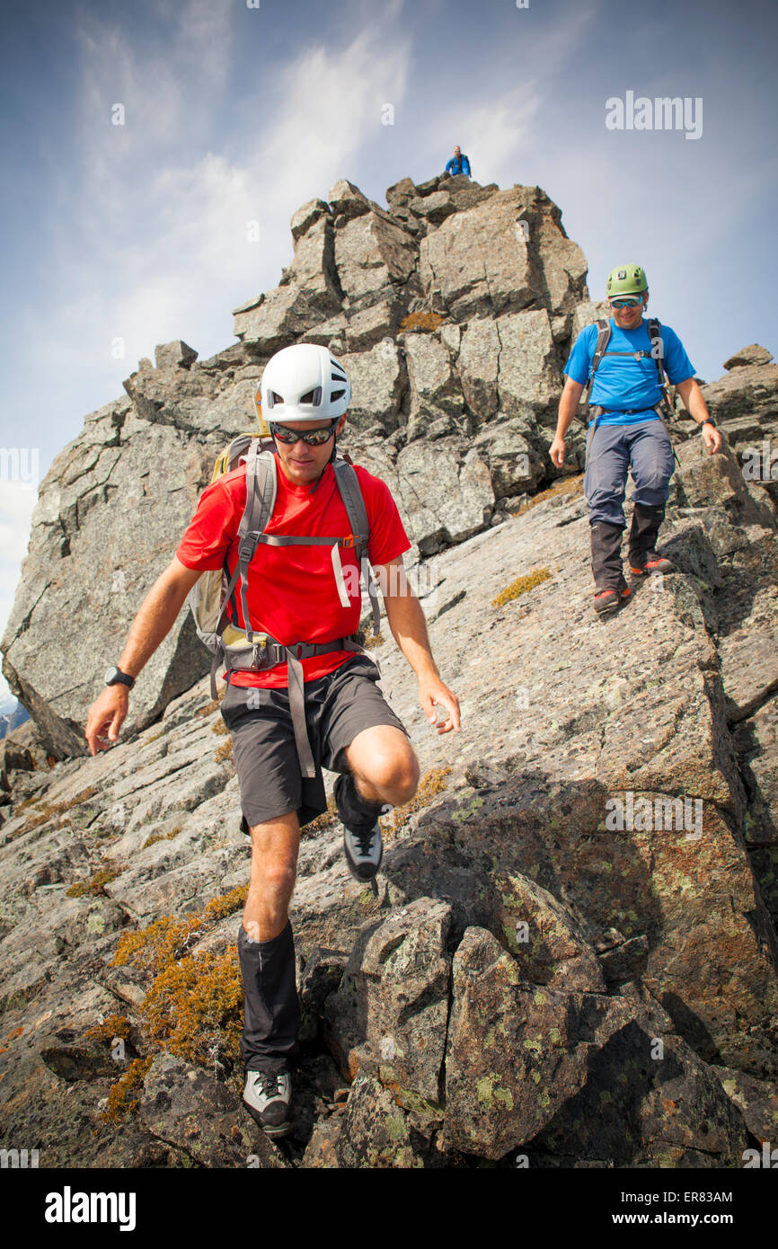 Three climbers descend from the summit of Trio Peak. Stock Photo