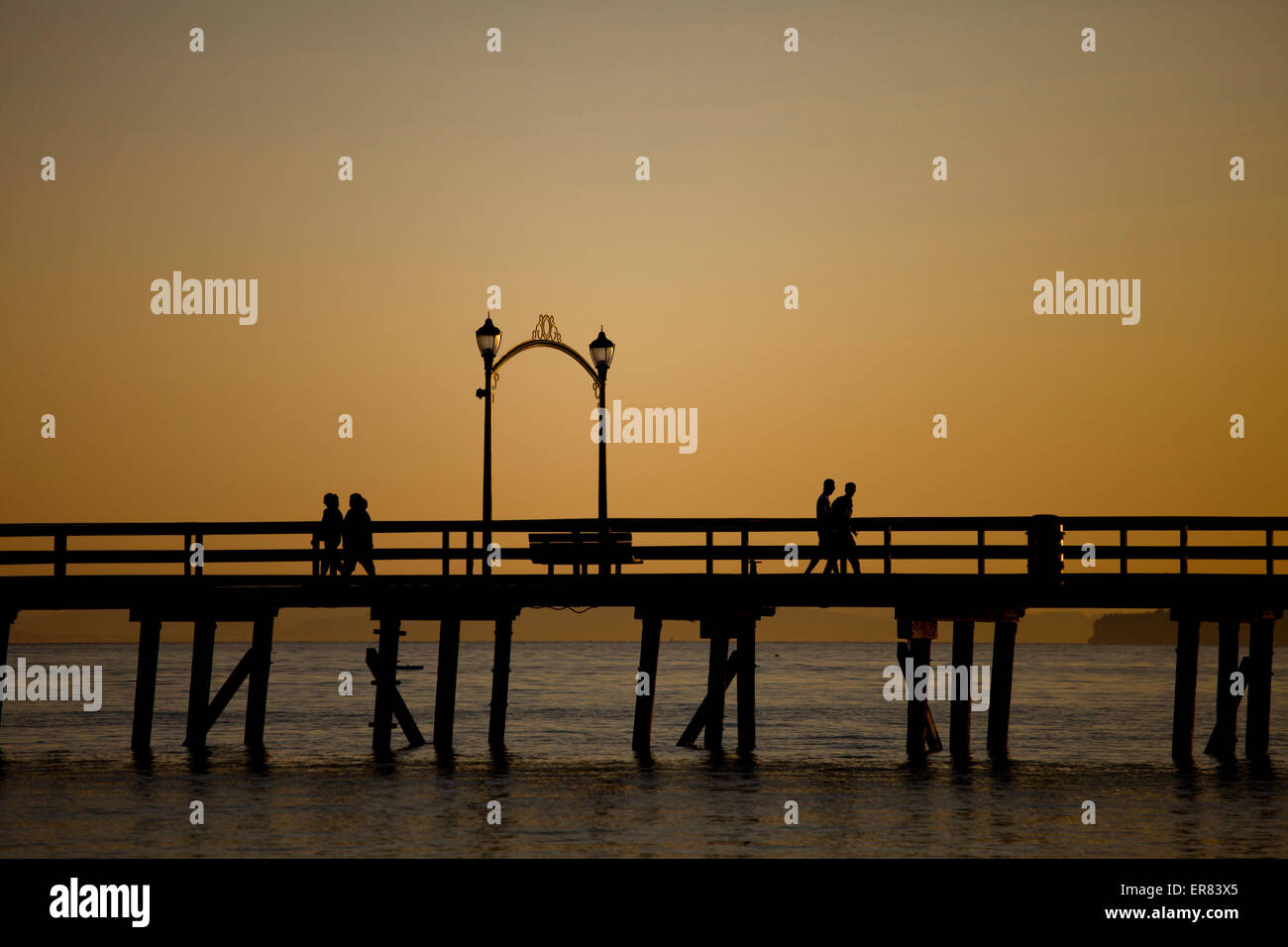 visitors walk the pier after sunset in White Rock , British Columbia. Stock Photo