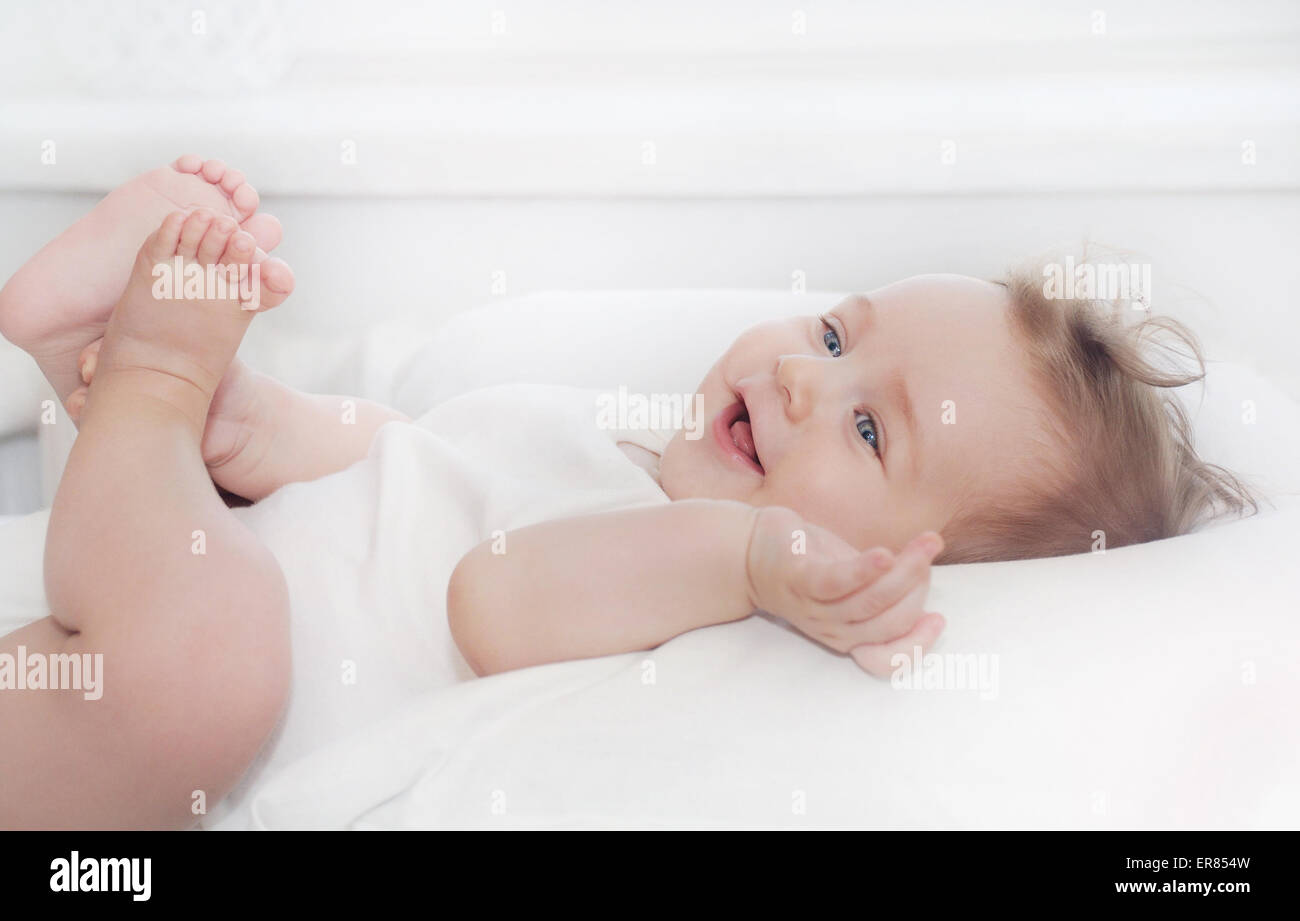 cute little happy baby boy lying on soft white pillow, happy family concept Stock Photo