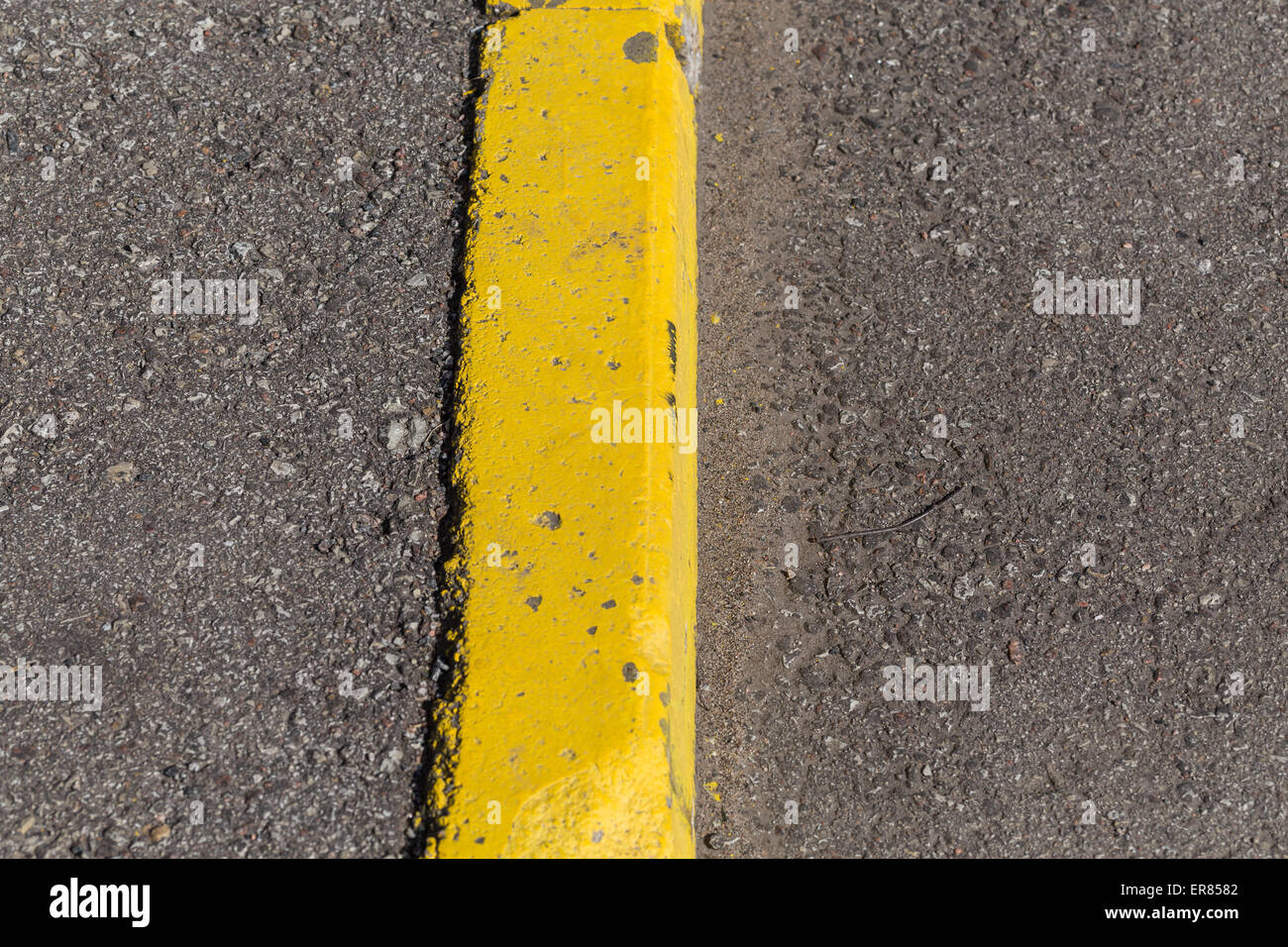 Yellow curb stone border and asphalt road Stock Photo Alamy