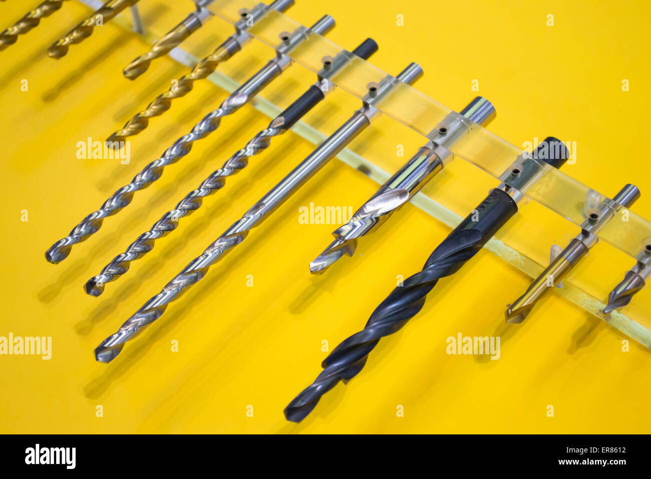 Set of steel drill bits in different sizes and materials displayed on