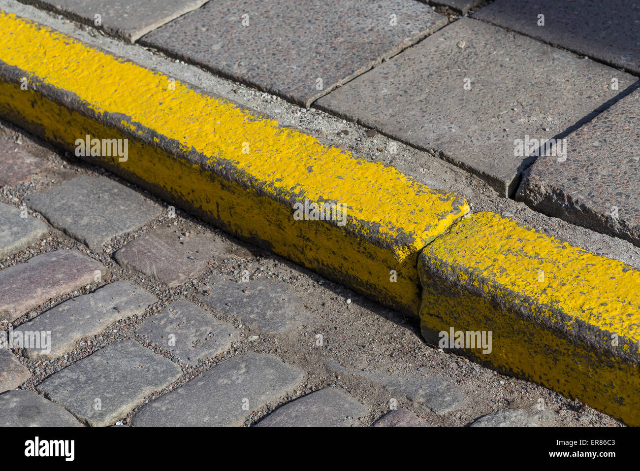 Yellow curb stone border in an old town road Stock Photo - Alamy