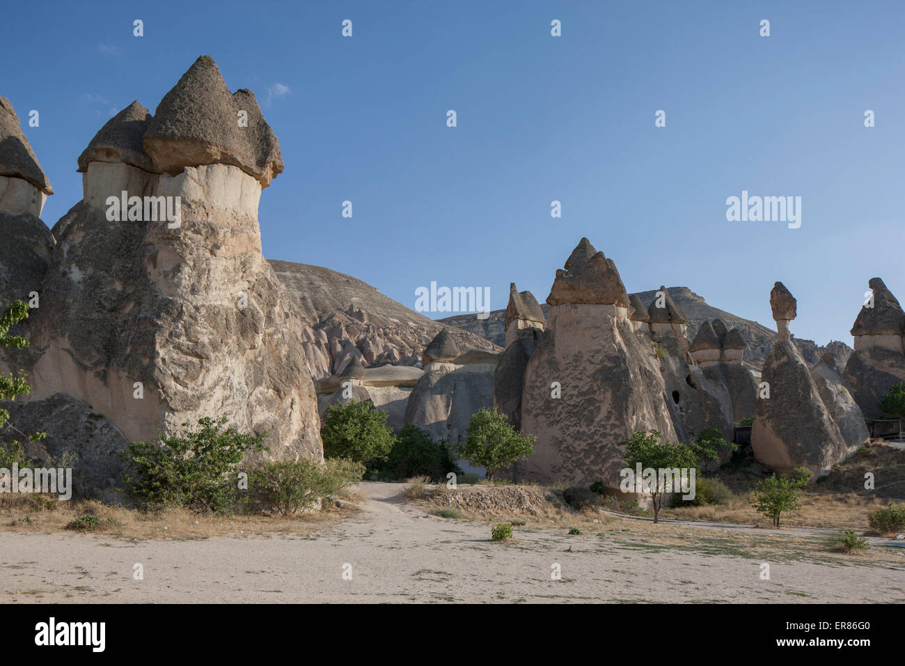 Eroded rock formations against clear blue sky Stock Photo