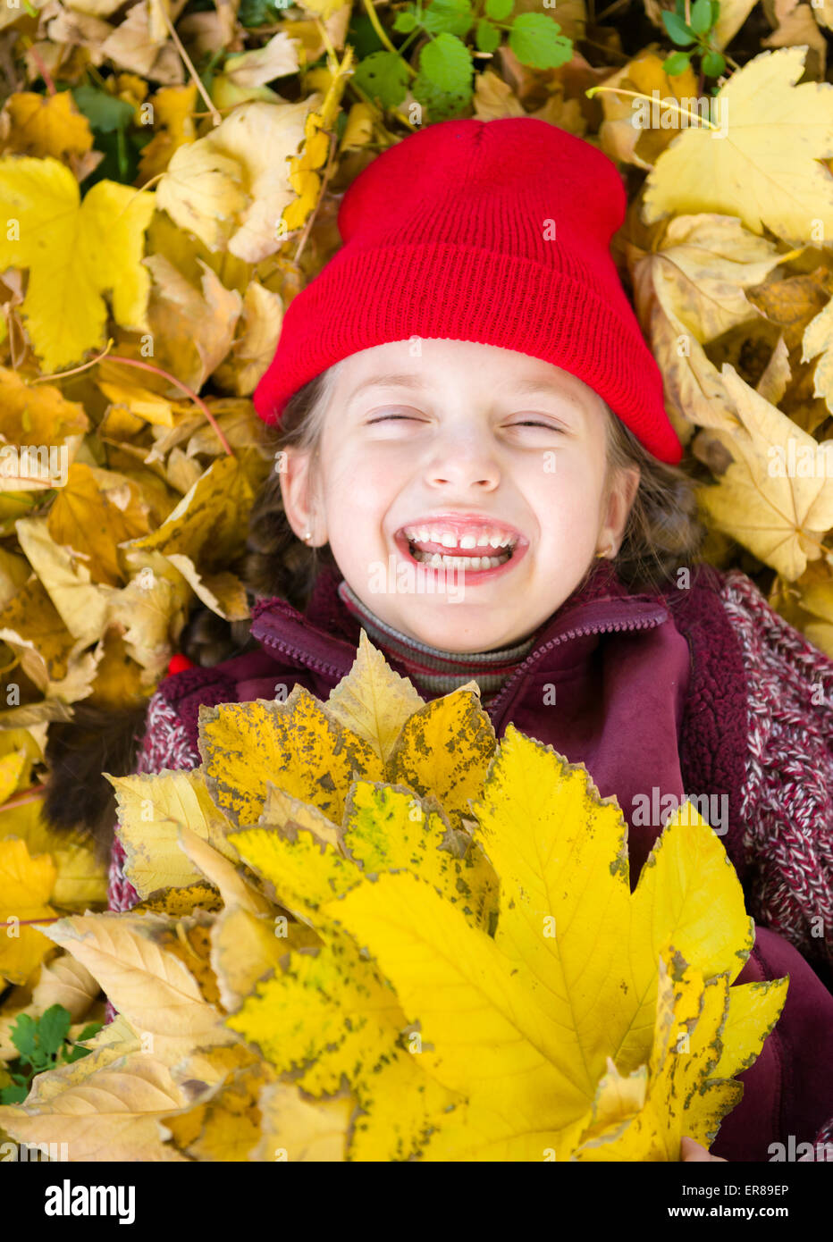 little girl in autumn park lying on leaves Stock Photo - Alamy