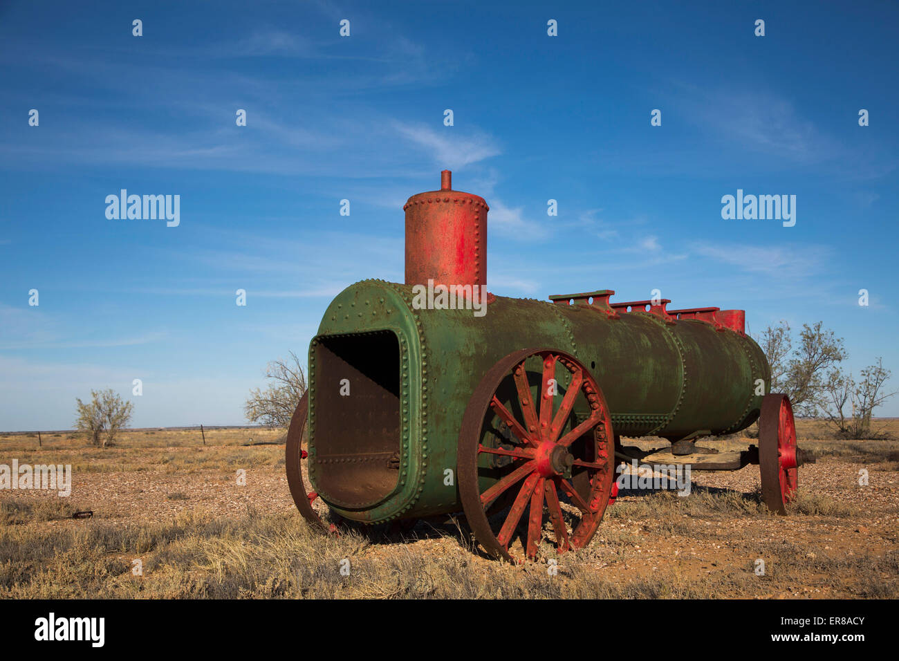 Abandoned steam engine on field against blue sky Stock Photo