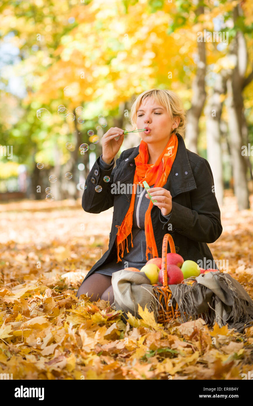pregnant woman blow bubbles in autumn park Stock Photo