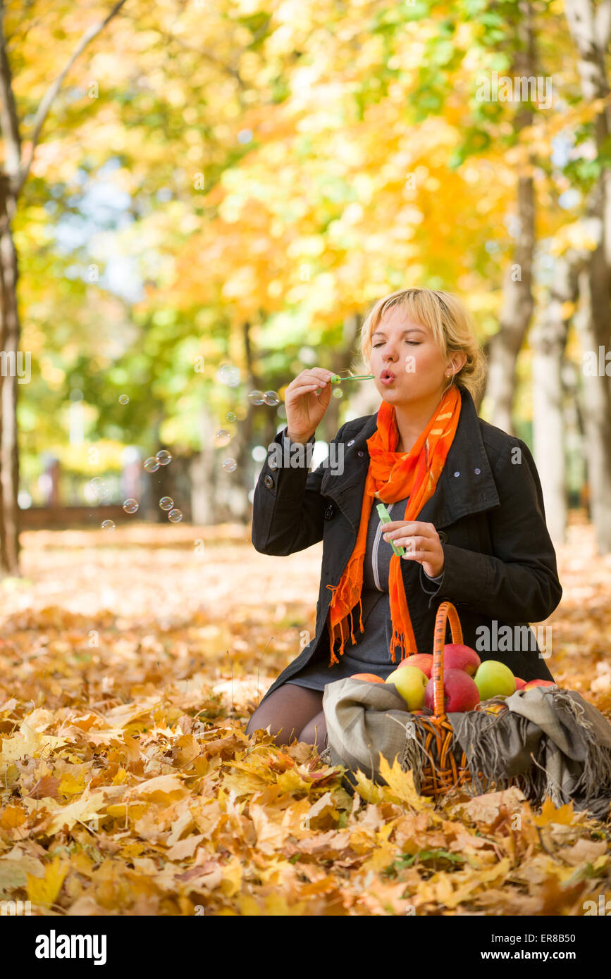 pregnant woman blow bubbles in autumn park Stock Photo