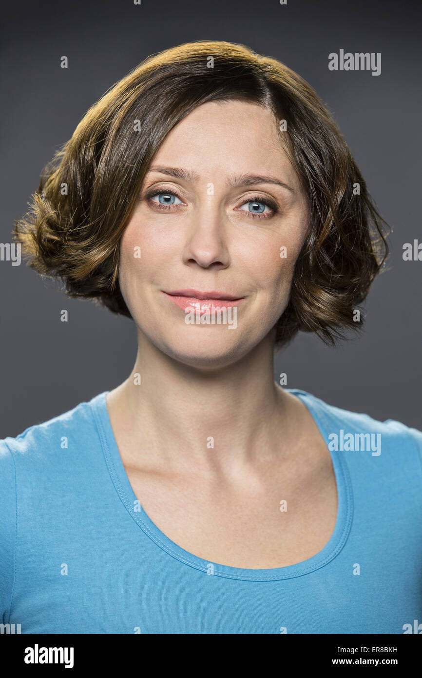 Portrait of happy mid adult woman over gray background Stock Photo