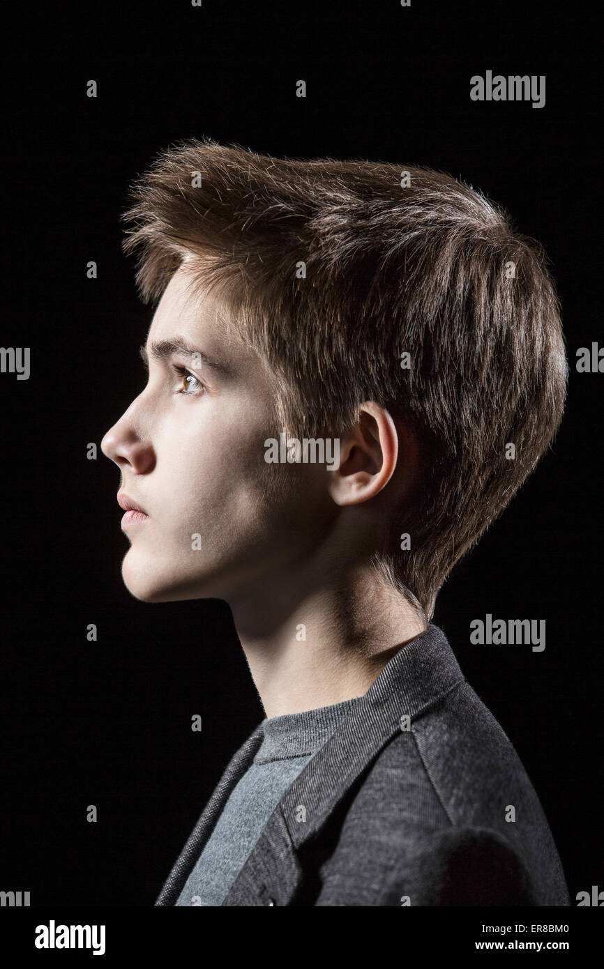 Profile shot of teenage boy over black background Stock Photo