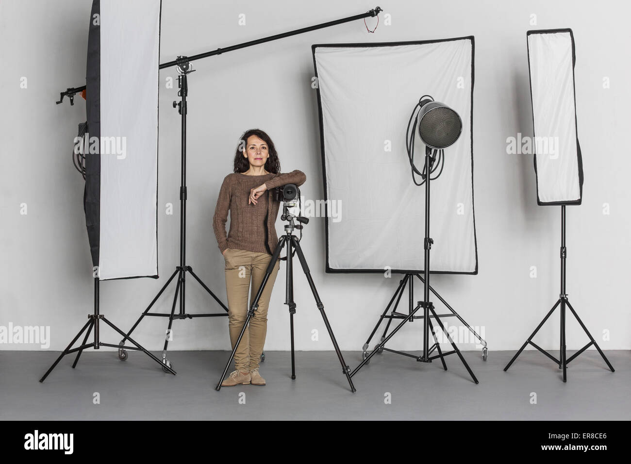 Full length of confident mature female photographer in photo studio Stock Photo