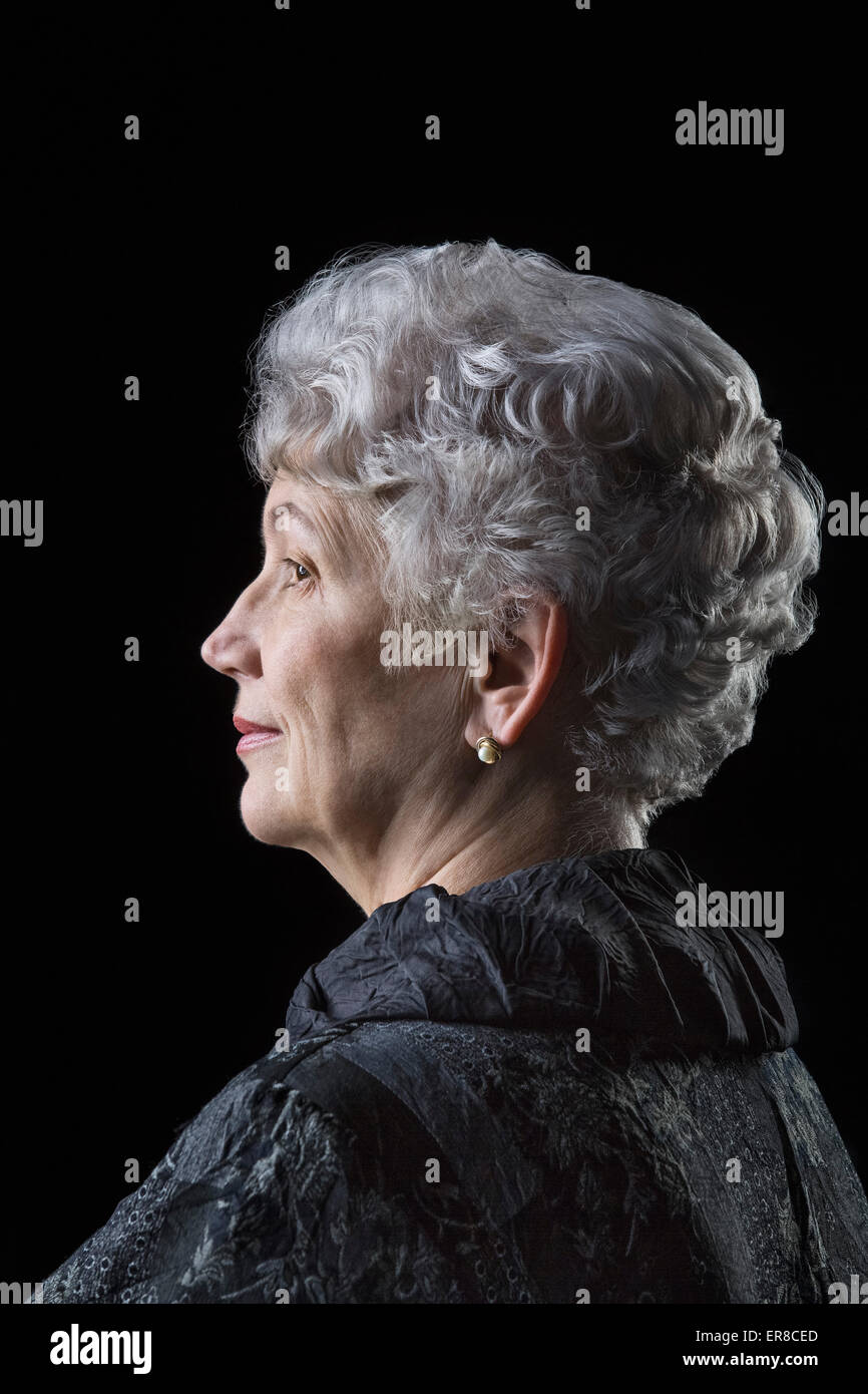 Side view of senior woman over black background Stock Photo