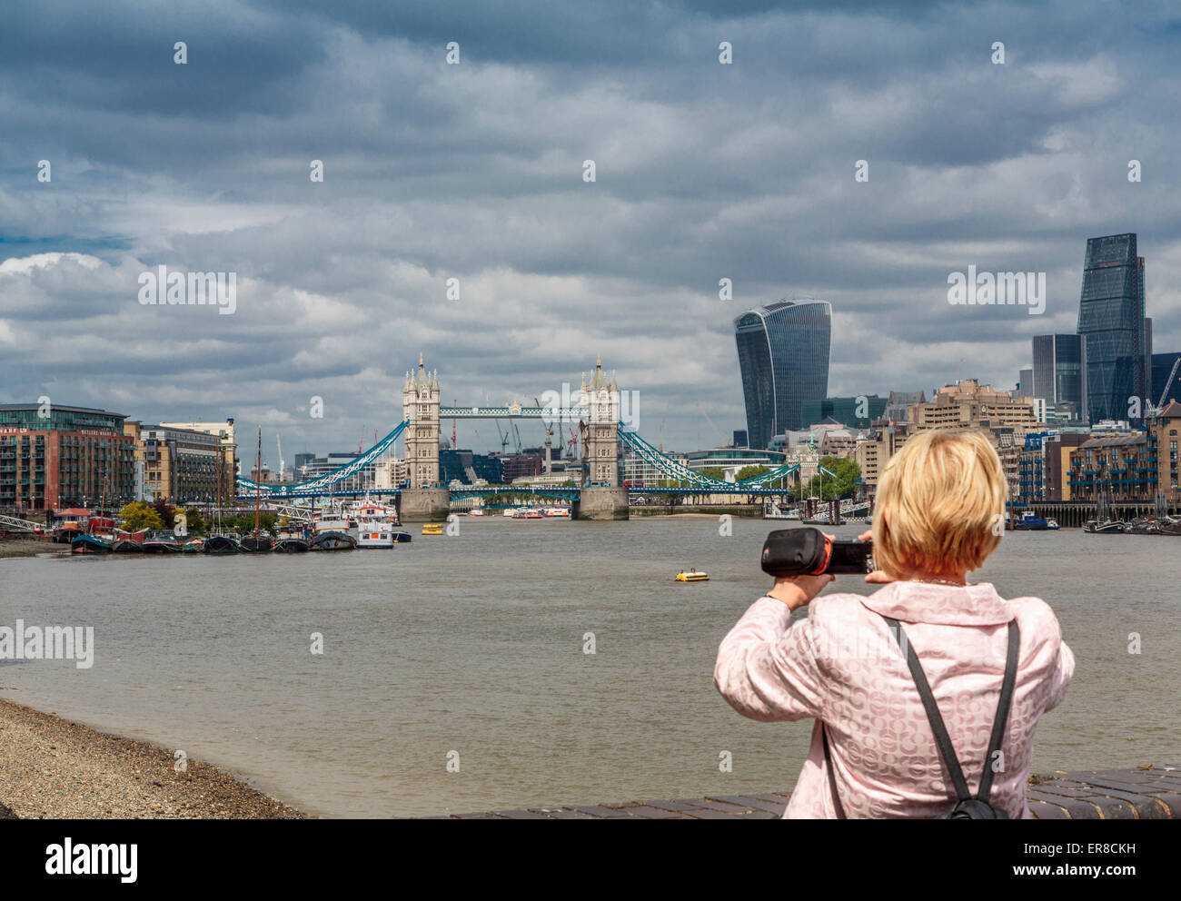A Tourist taking a photograph of The River Thames looking West towards Tower Bridge and the Walkie Talkie Building, London, UK Stock Photo