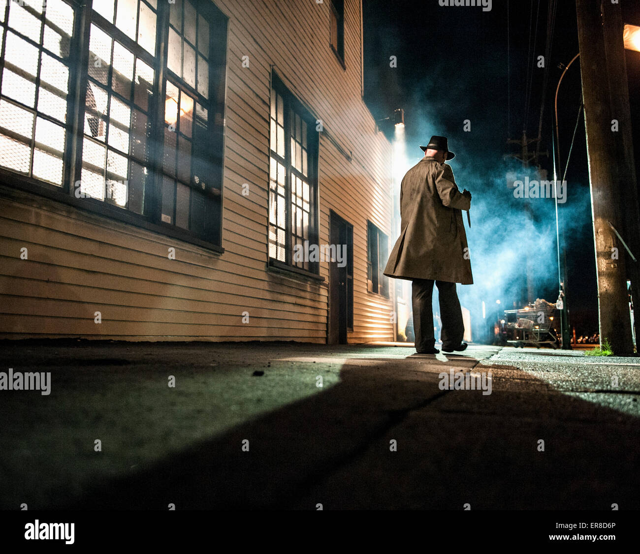 Rear view of man walking outside building at night Stock Photo - Alamy