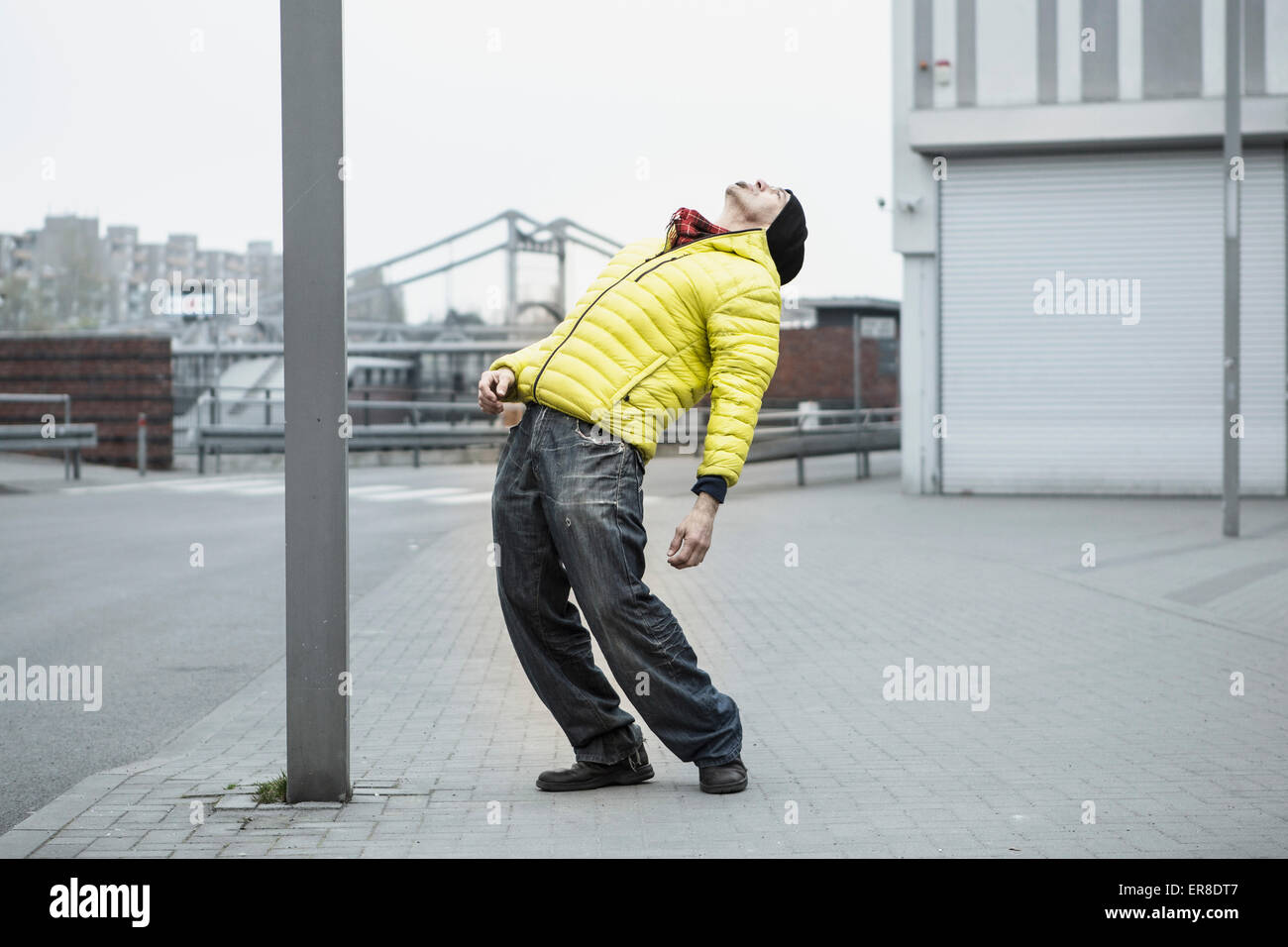 Full length of mature man stretching backward on sidewalk Stock Photo