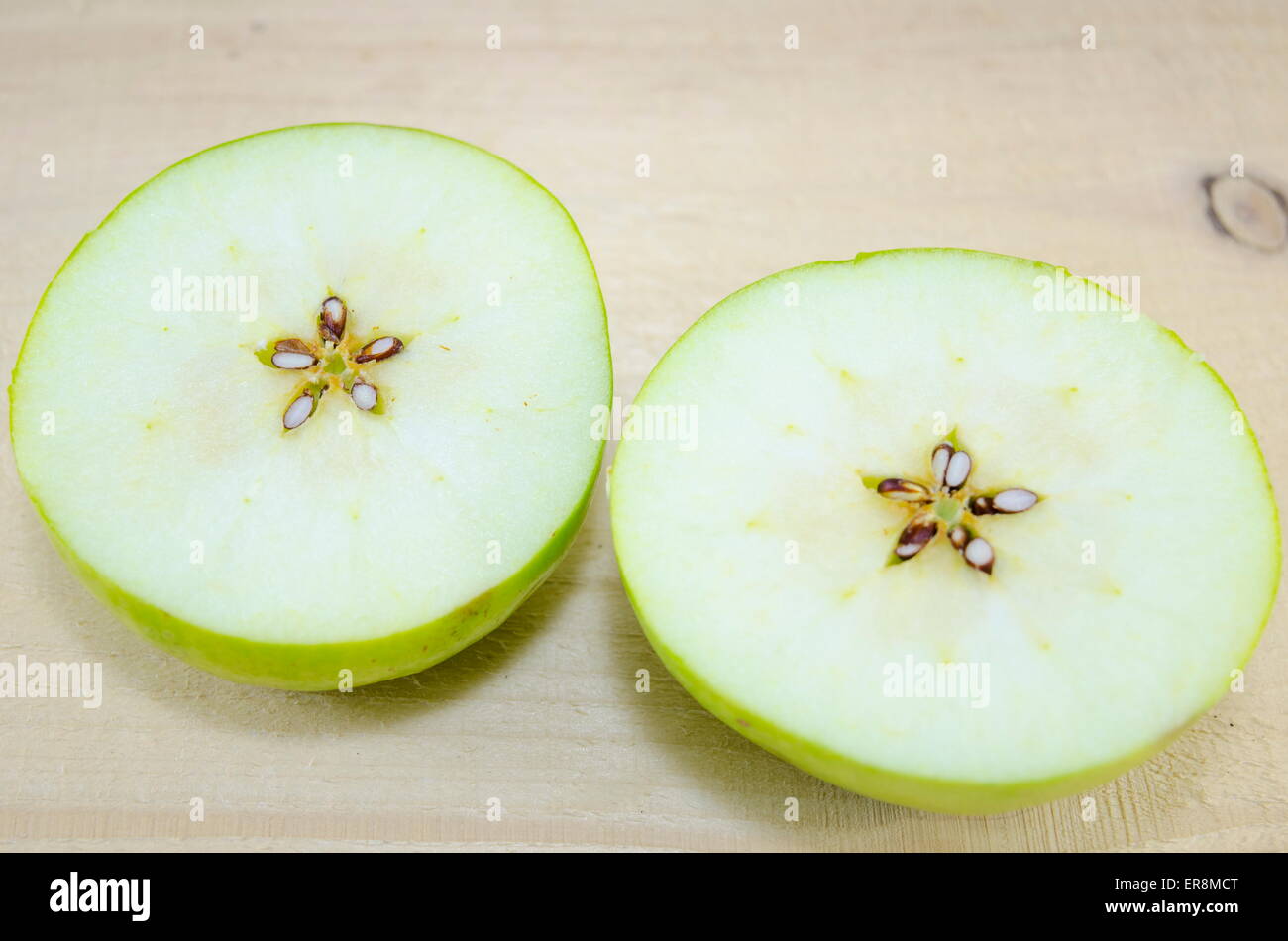 Apple sliced in thin pieces on a wooden table Stock Photo
